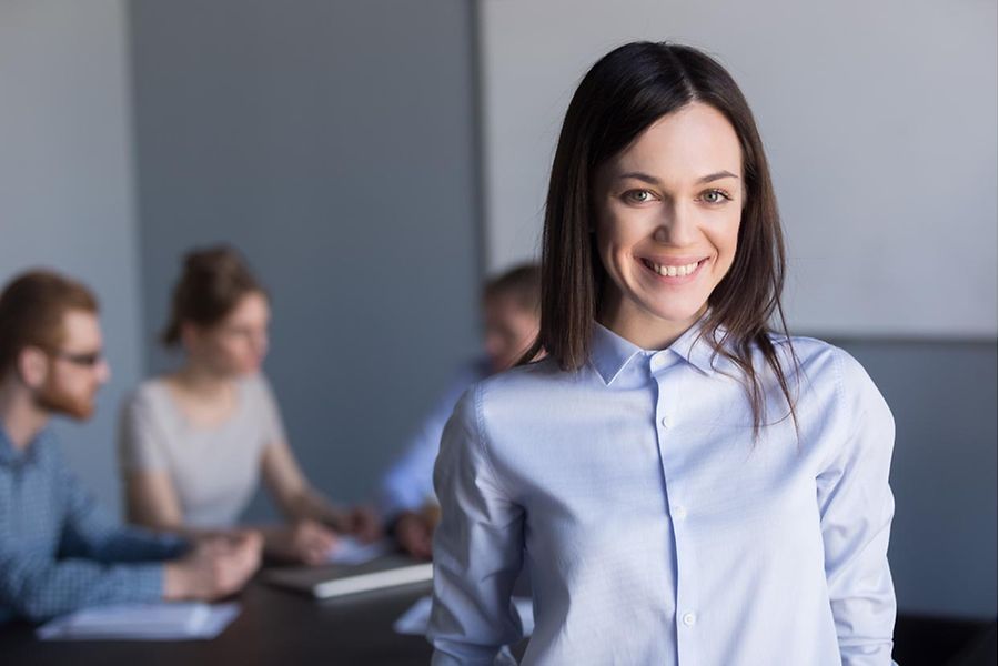 Portrait,Of,Smiling,Female,Employee,Looking,At,Camera,During,Office